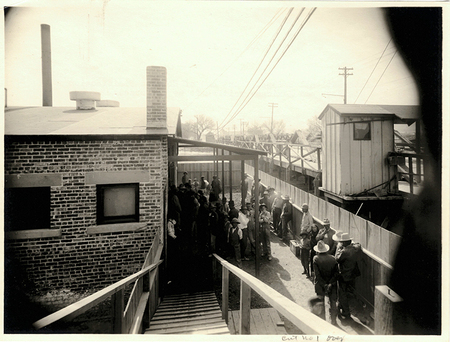Dozens of Mexican men, women, and children wait in line for chemical delousing baths at El Paso Quarantine Station